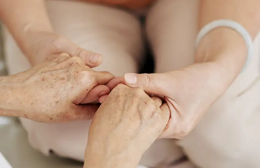 Quattro mani che si congiungono in un gesto di solidarietà.