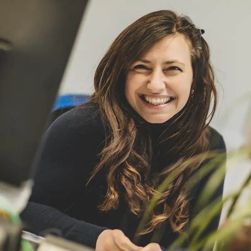 Una signora sorridente che lavora alla Fondazione Gigi Ghirotti presta il suo volto per la campagna di raccolta donazioni.