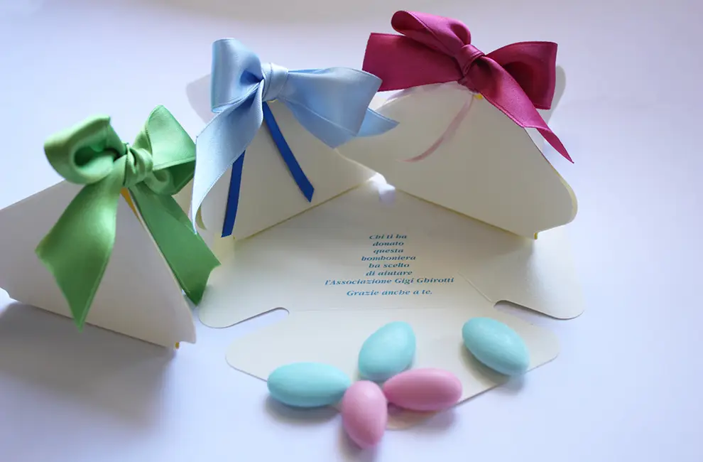 Bomboniere con grandi fiocchi colorati e confetti della fondazione Gigi Ghirotti.