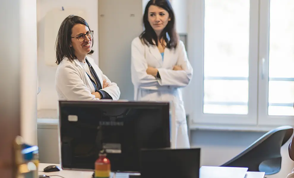 Due giovani dottoresse conversano in uno degli studi medici.