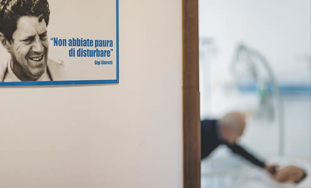 Sulla parete davanti all'inresso di una stanza, una immagine di Gigi Ghirotti e una sua frase celebre: "Non abbiate paura di disturbare",