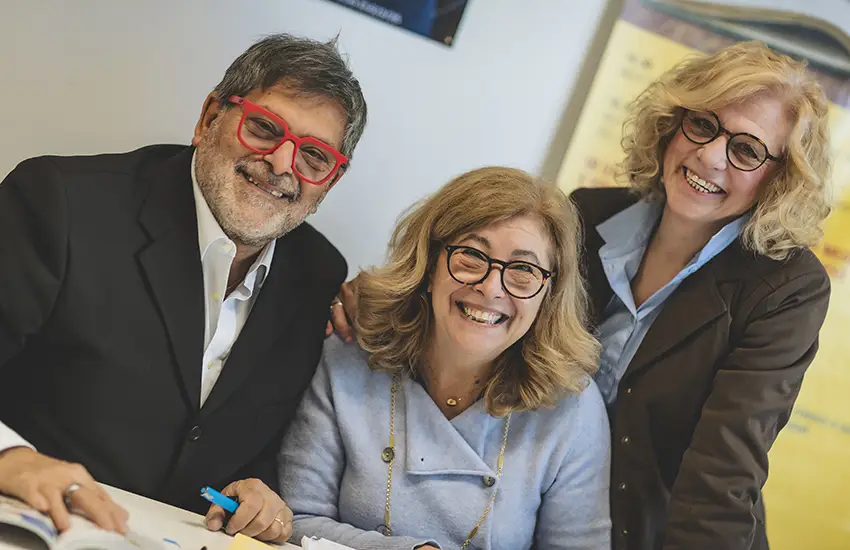 Maurizio Bosano volontario e responsabile ufficio promozione della fondazione Gigi Ghirotti, ci sorride assieme ad altre due signore , anche loro volontarie.
