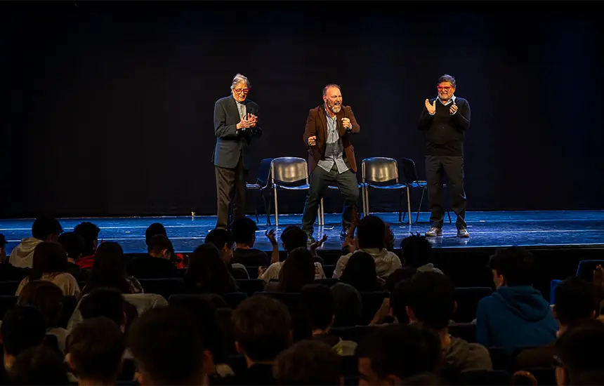 Il prof. Franco Henriquet insieme a Maurizio Bosano resp. ufficio promozione della fondazione Gigi Ghirotti, sul palcoscenico teatrale con Raffaele Casagrande autore ed interprete dello spettacolo. All'oscuro, in platea, gli spettatori.